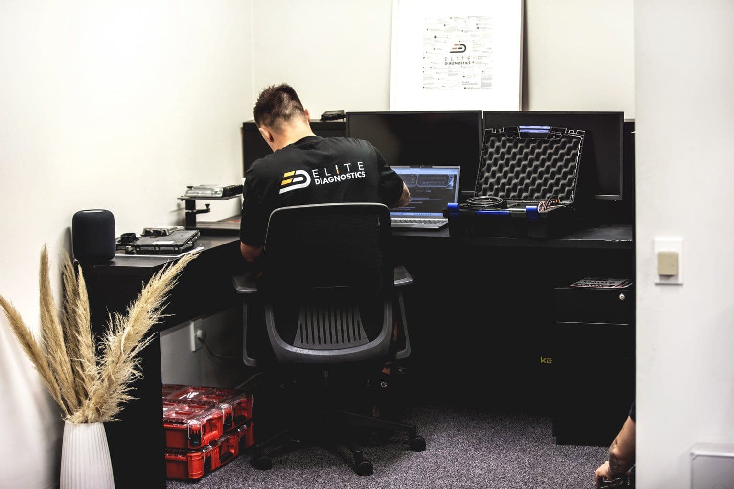 Technician at the diagnostic desk with oscilloscope and laptop